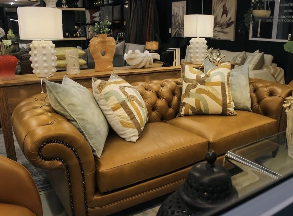 Caramel leather sofa styled with gold geometric pillows