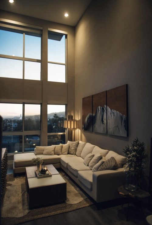 Cream L-shaped sectional sofa facing a mountain view through floor-to-ceiling windows